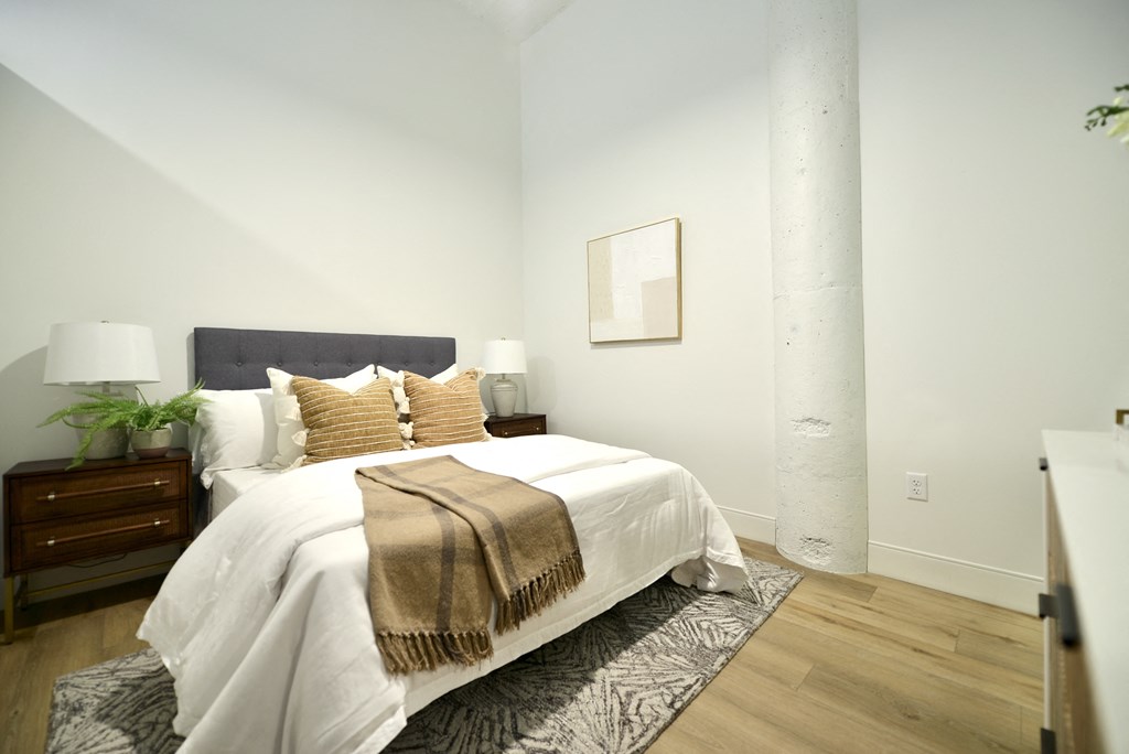 a bedroom with a white bed and a rug