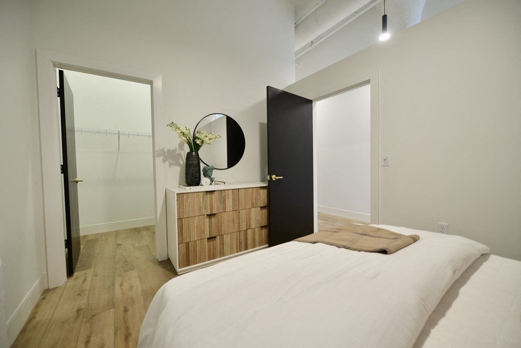 a bedroom with a bed and a dresser and a mirror