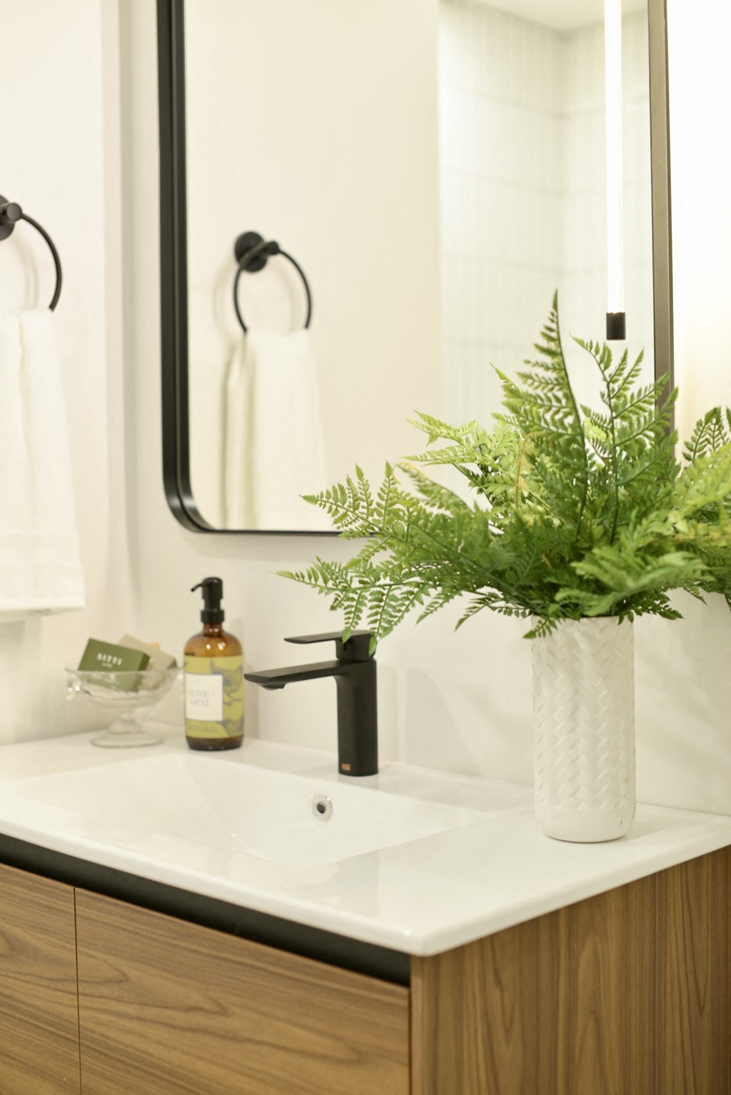 a bathroom sink with a vase of flowers on it