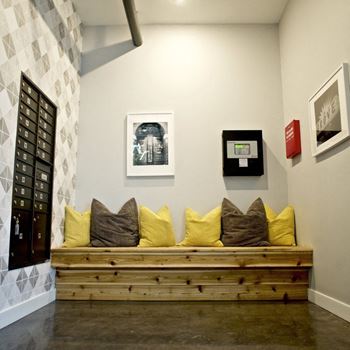 A room with a wooden bench and a painting on the wall.
