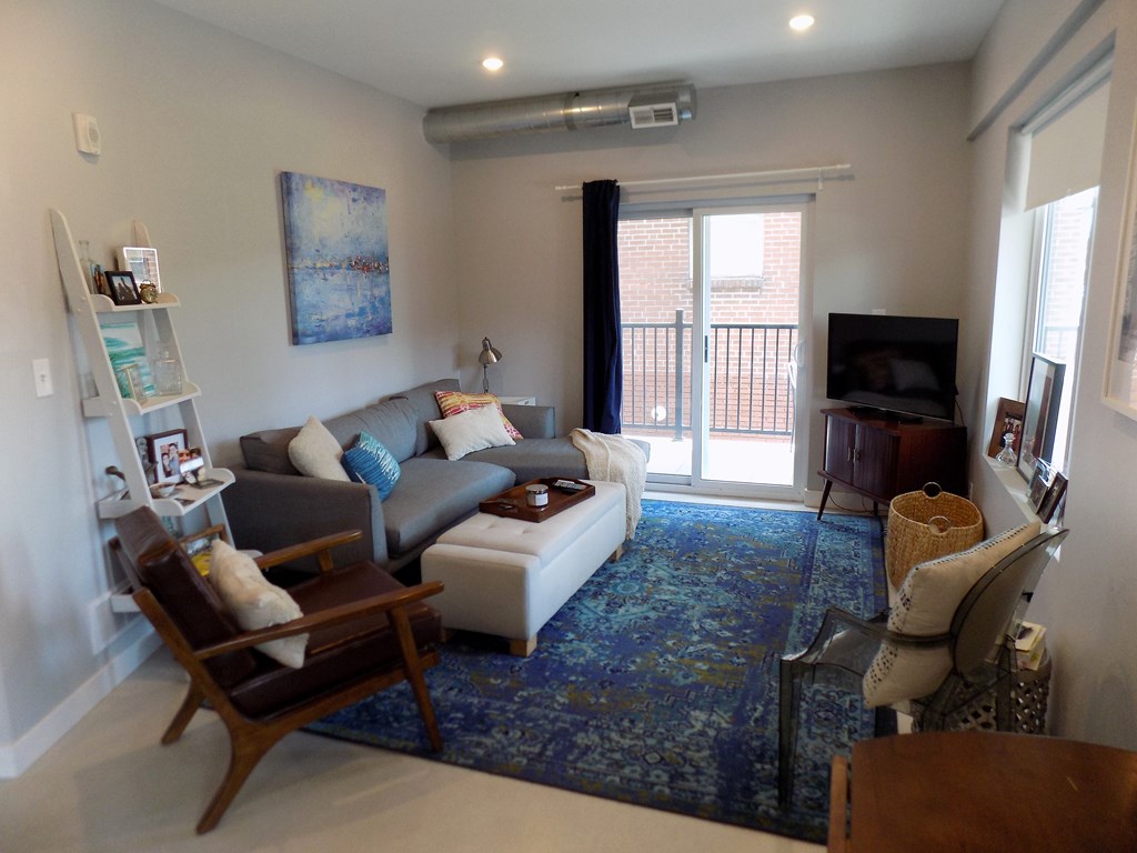 A living room with a couch, chair, and television.