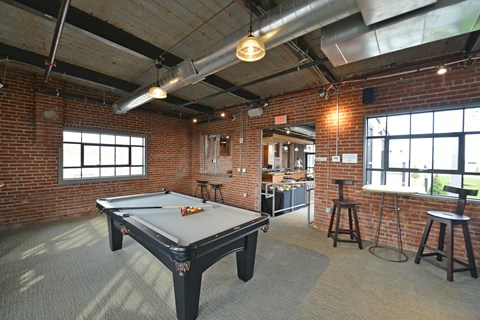 a game room with a pool table and a kitchen in a loft