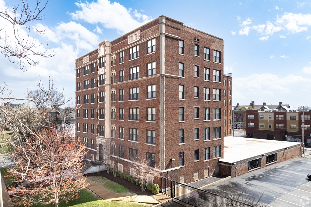 A large red brick building with a parking lot in front.