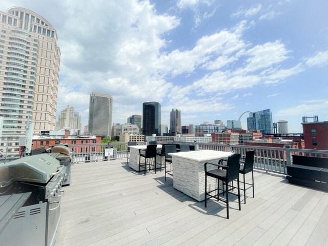 a rooftop terrace with a table and chairs and a view of the city