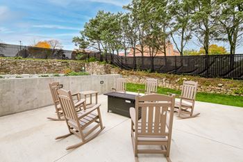 a patio with a table and chairs and a fire pit