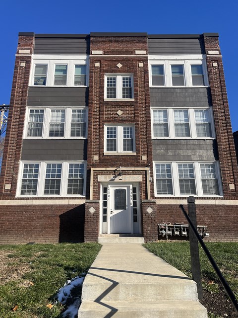the front of a brick building with a white door