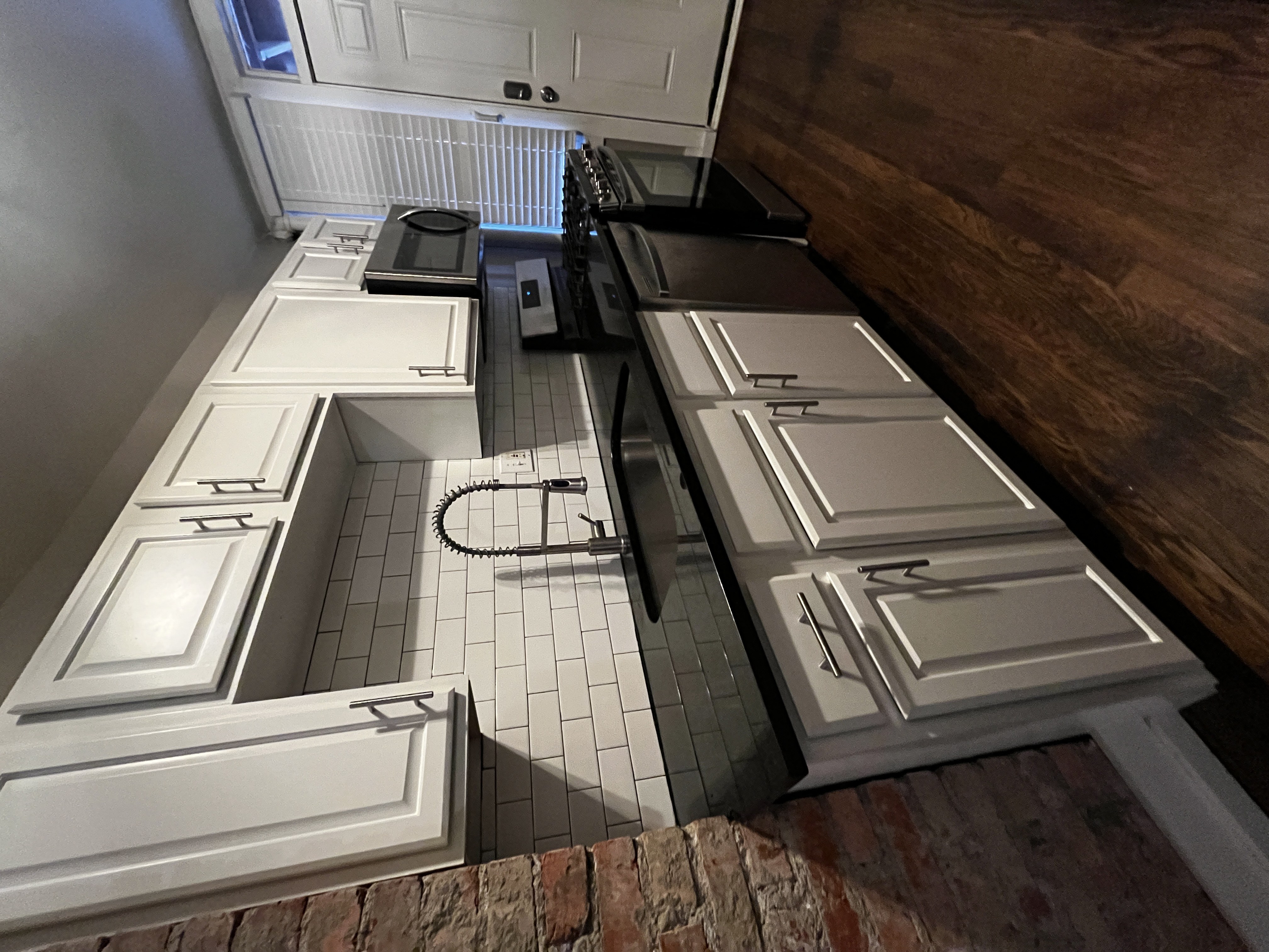 a kitchen with white cabinets and a wood floor