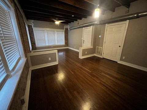 an empty living room with wood floors and a window