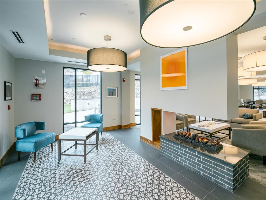 a living room with a fireplace and blue chairs