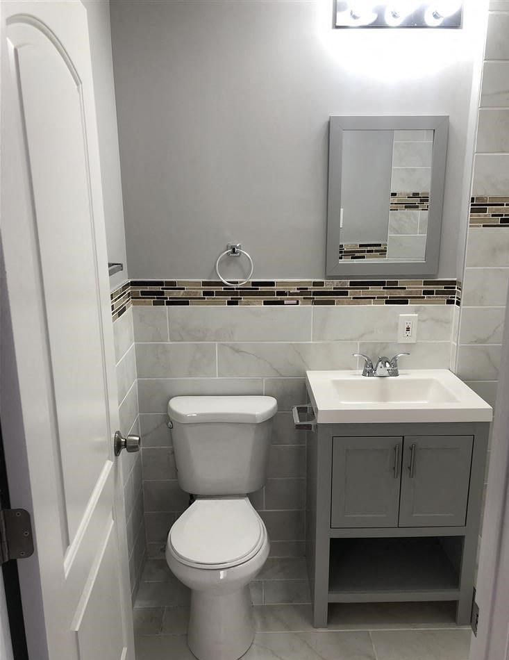 A white toilet sits next to a sink in a bathroom.