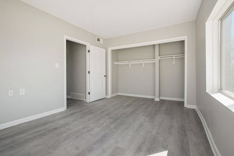 bedroom faux wood floor with a closet and a window