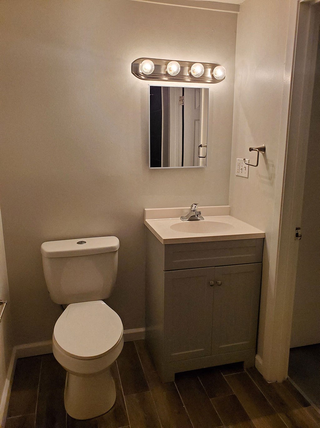 a small bathroom with a toilet and a light on the wall