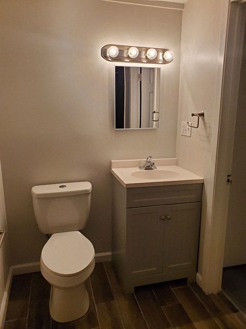 a small bathroom with a toilet and a light on the wall