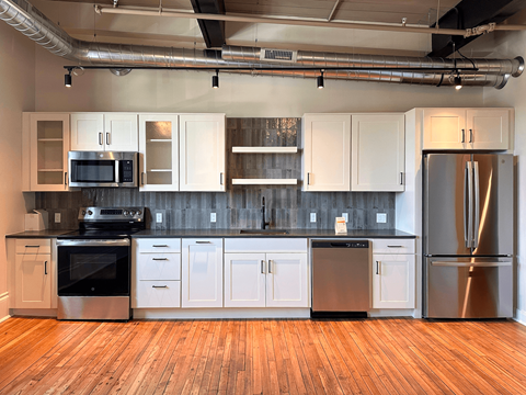 A kitchen with white cabinets and stainless steel appliances.
