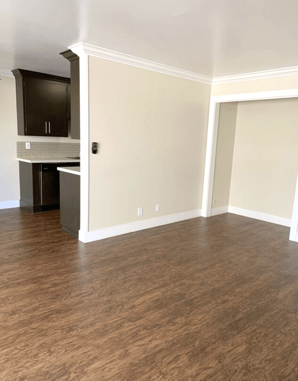 A kitchen with a black cabinet and a white wall.