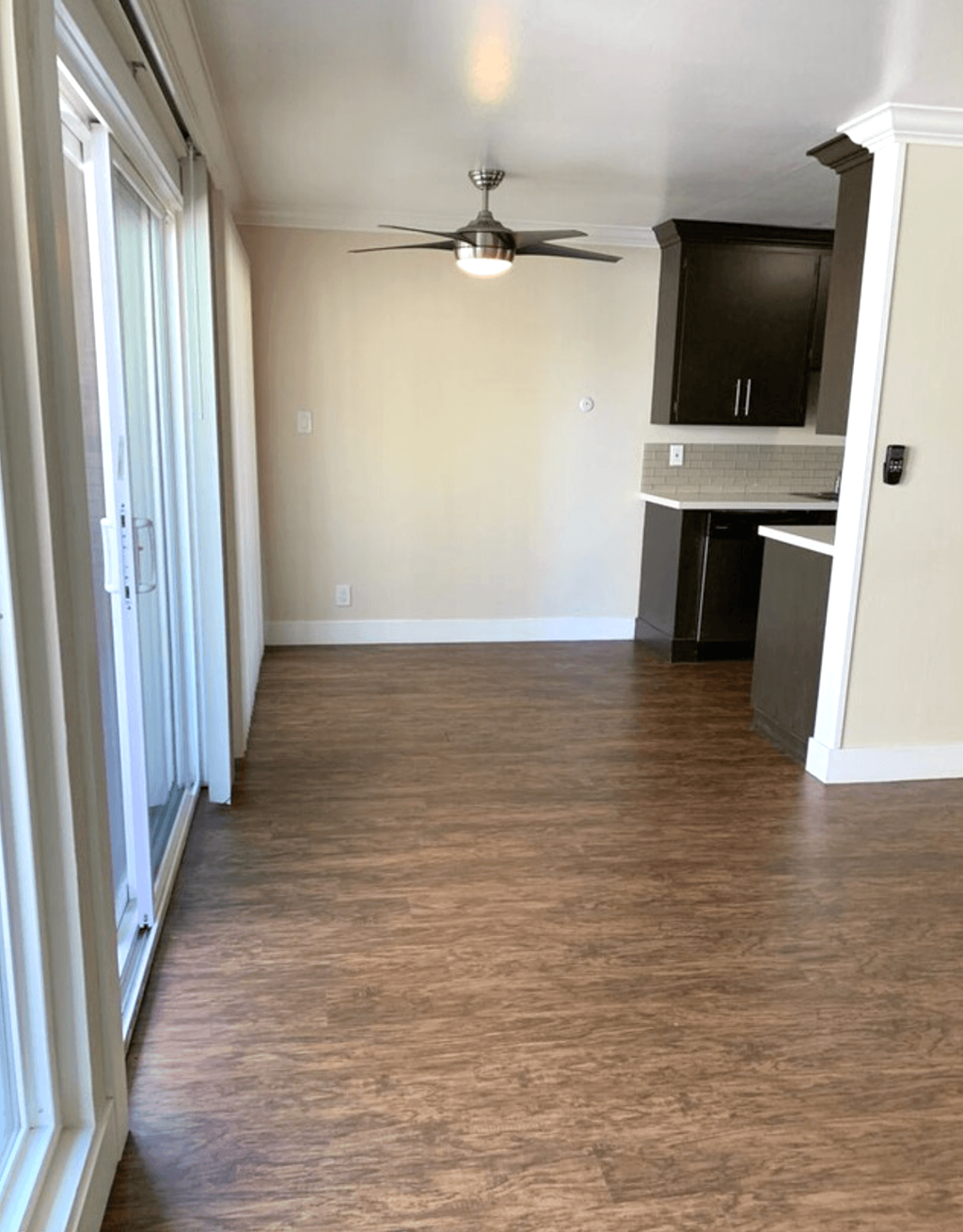 A room with a ceiling fan and a cabinet.