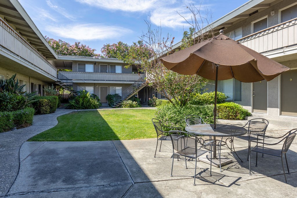 a patio with a table and chairs and an umbrella