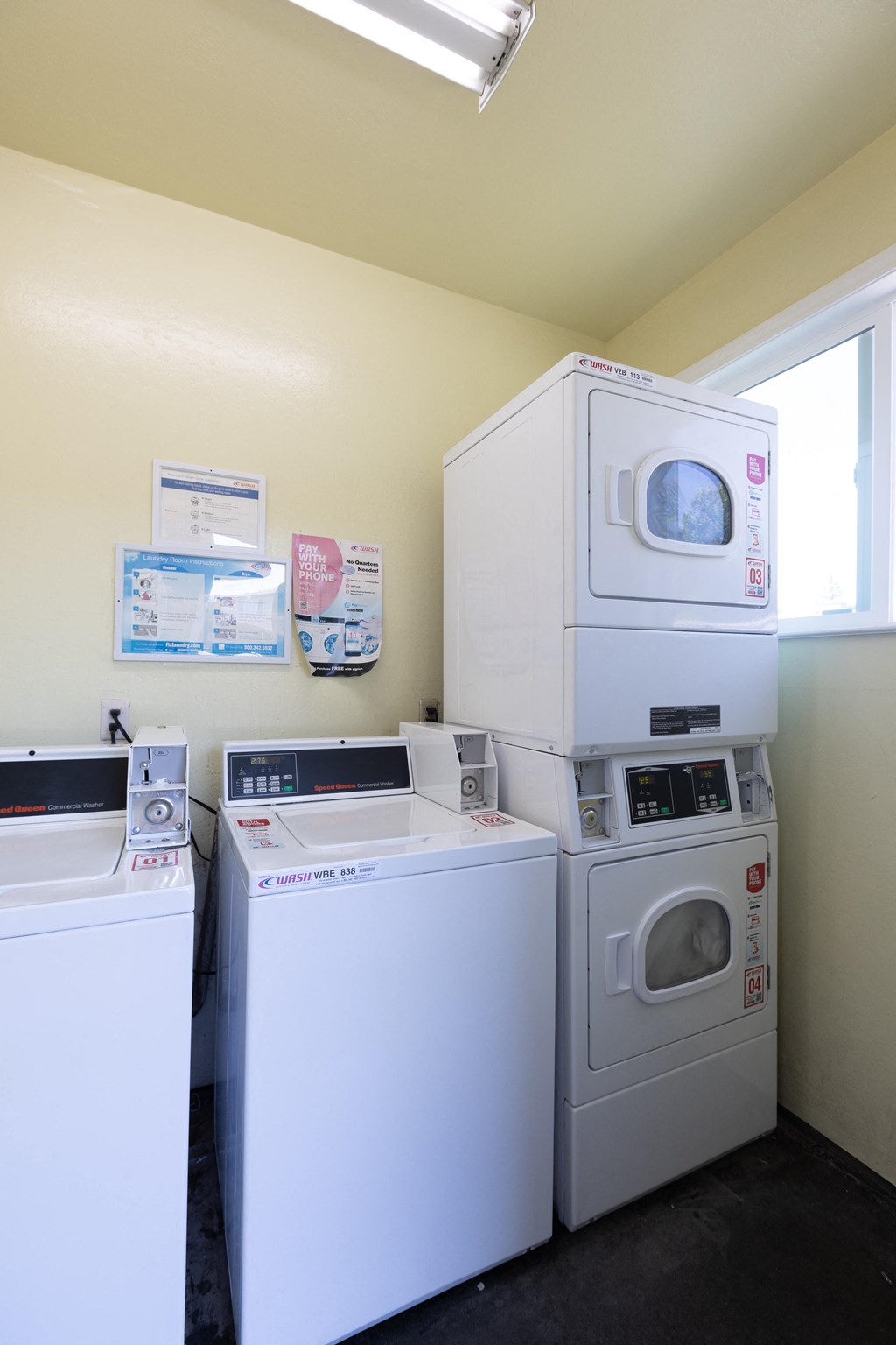 a laundry room with two washers and two washing machines