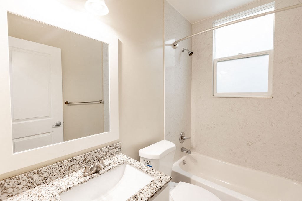 a bathroom with a mirror and a sink and a toilet