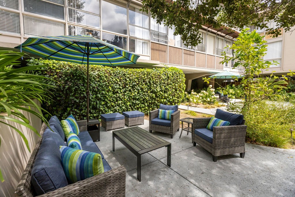 A patio with a table, chairs, and an umbrella.