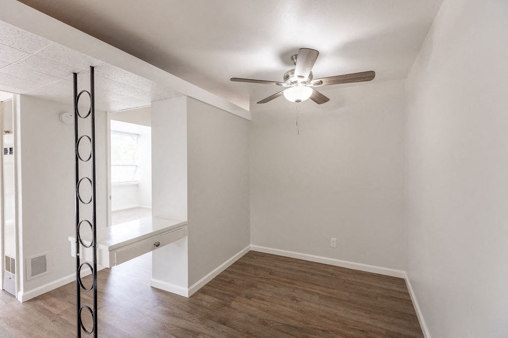 A room with a ceiling fan and a window.