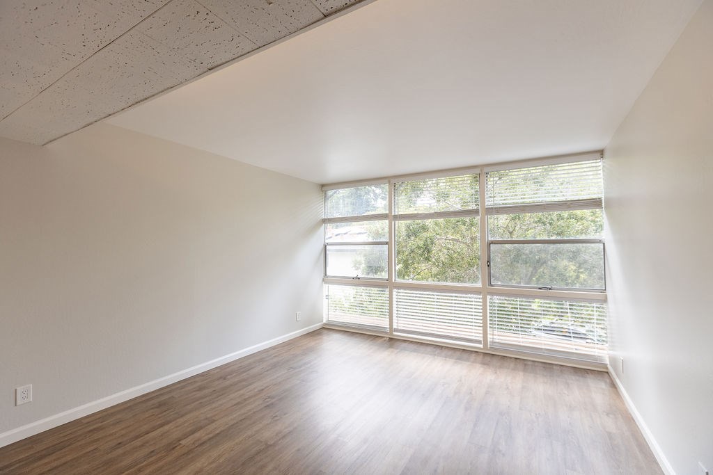 A room with a window and wooden flooring.