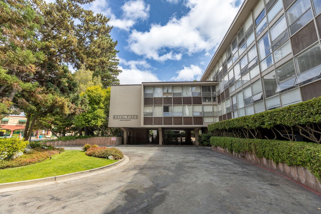 The image shows a building with the name "Royal Fines" on it, surrounded by greenery and a paved area in front.