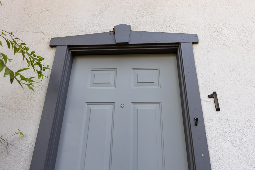 A white door with a black frame and a number 1 on the wall.