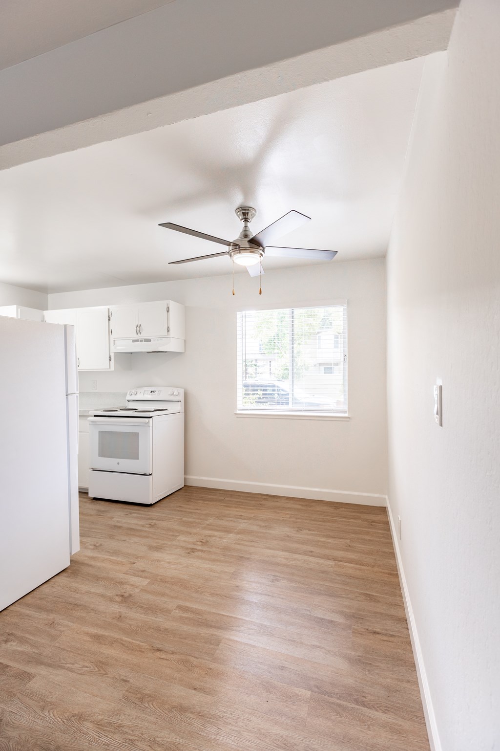 A room with a ceiling fan and a window.