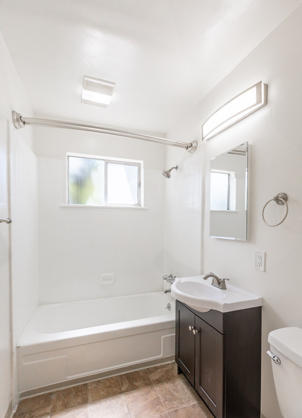 A bathroom with a white tub, sink, and toilet.