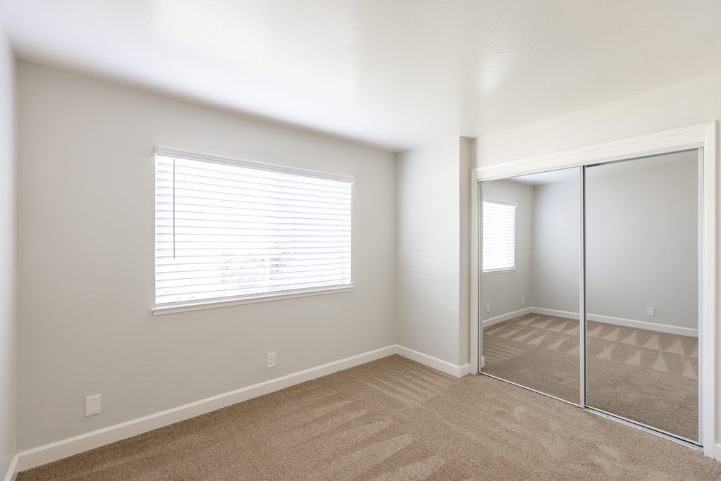 A room with a carpeted floor and a sliding glass door.
