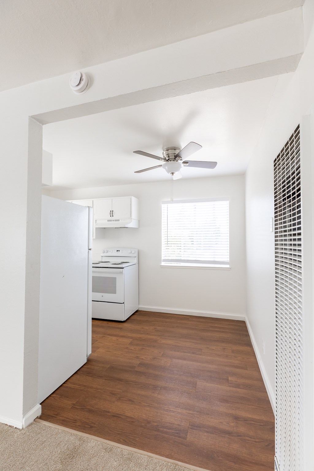 A kitchen with a white fridge, stove, and dishwasher.