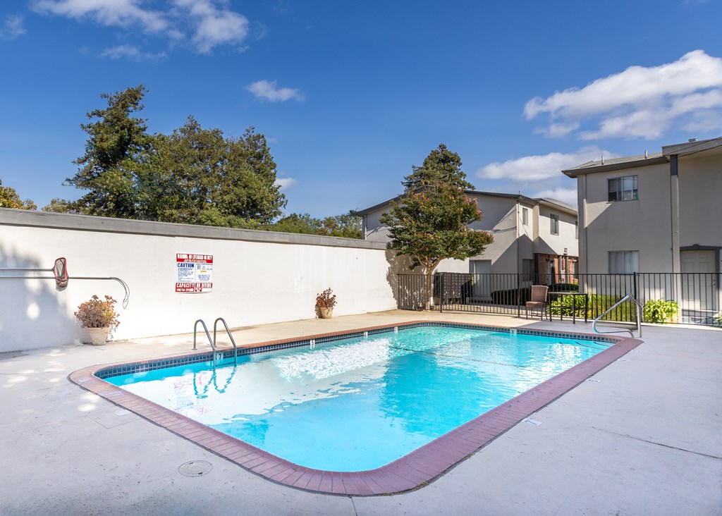 A pool with a red border and a white wall with a Netflix sign.