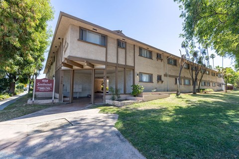 the front of a building with a sidewalk and grass