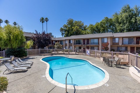 our apartments have a large pool and a patio with chairs