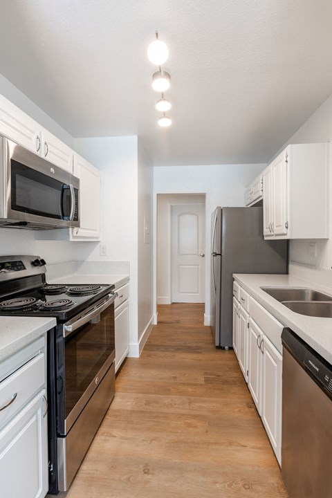 A kitchen with white cabinets and stainless steel appliances.