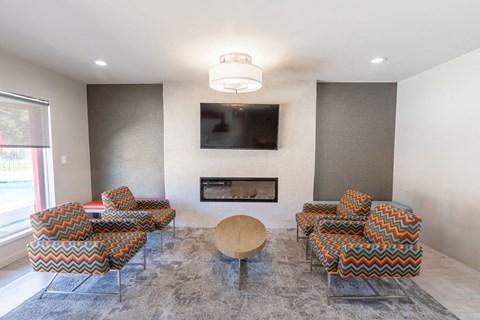 A living room with a fireplace and a television mounted on the wall.