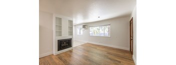 an empty living room with a fireplace and a window