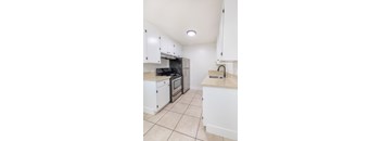 a kitchen with white cabinets and a sink and a stove