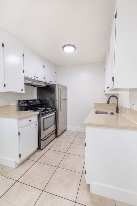 A kitchen with white cabinets and appliances.