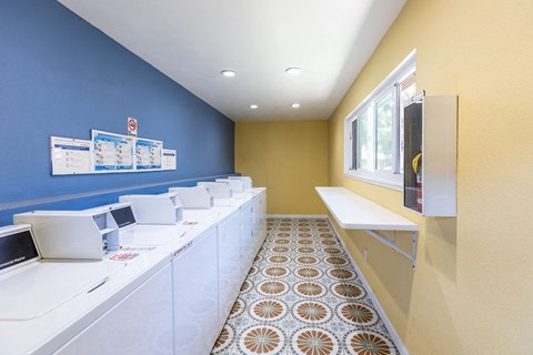 A row of white washing machines in a laundromat.
