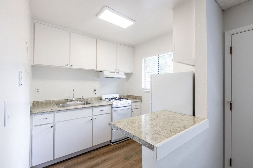 a kitchen with white cabinets and a counter top