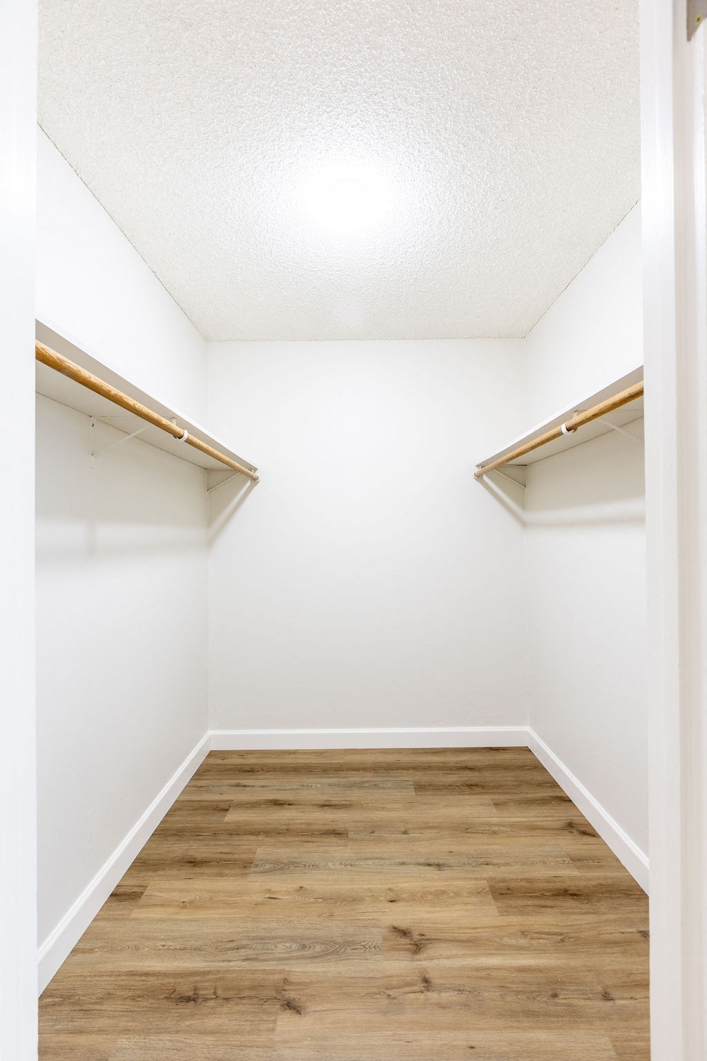 a room with a wood floor and a closet with shelves