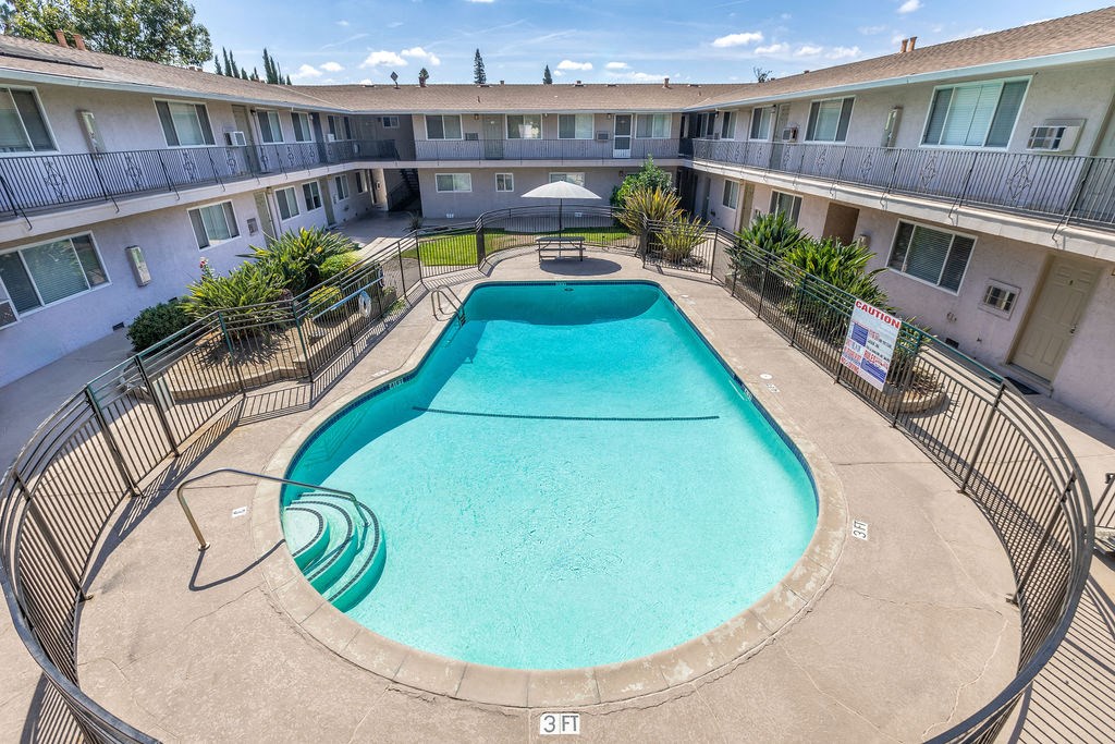 a resort style pool is in the middle of an apartment building