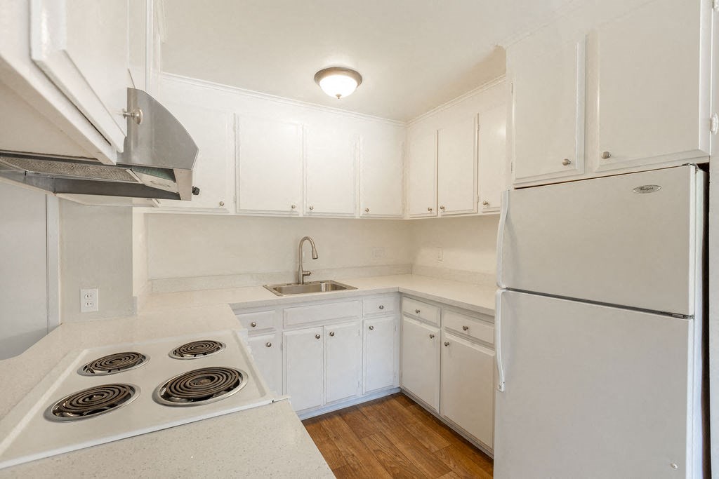 a kitchen with white cabinets and a white refrigerator