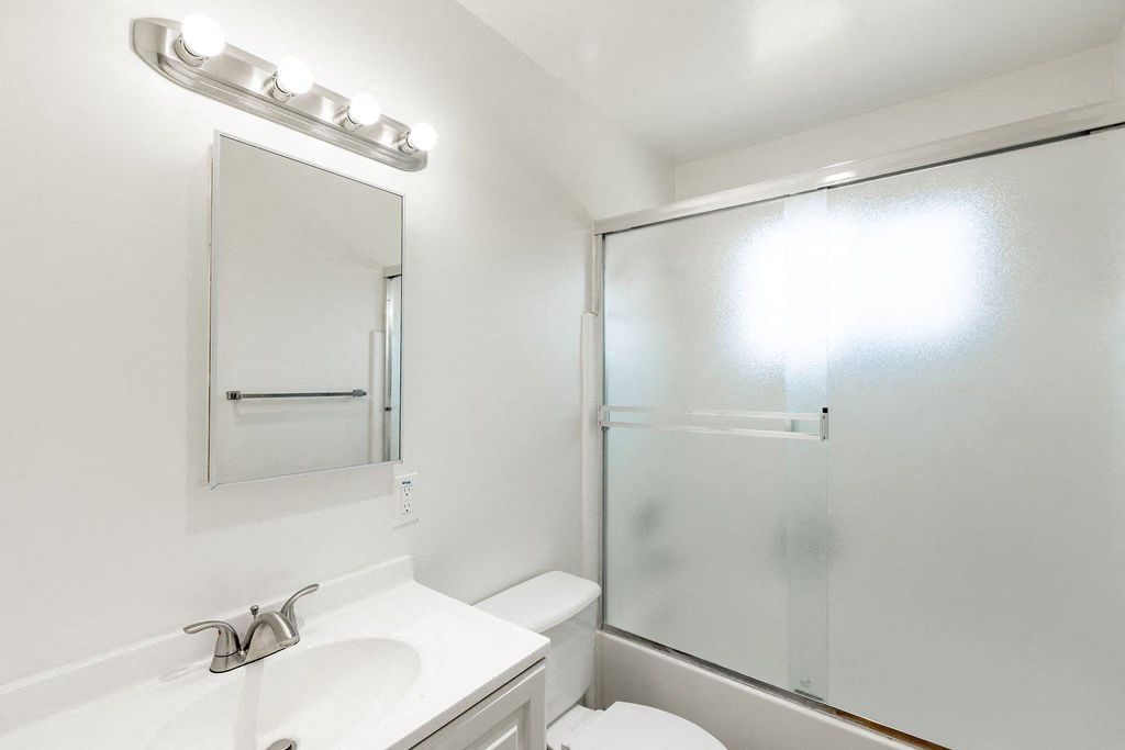 a bathroom with a shower and a sink and a mirror