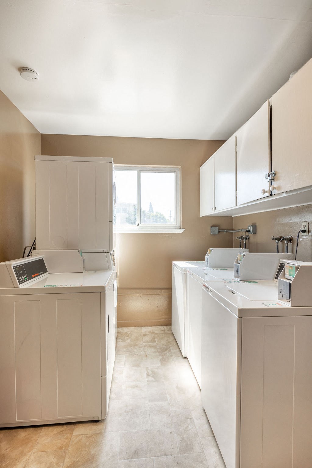 a white kitchen with white cabinets and a window