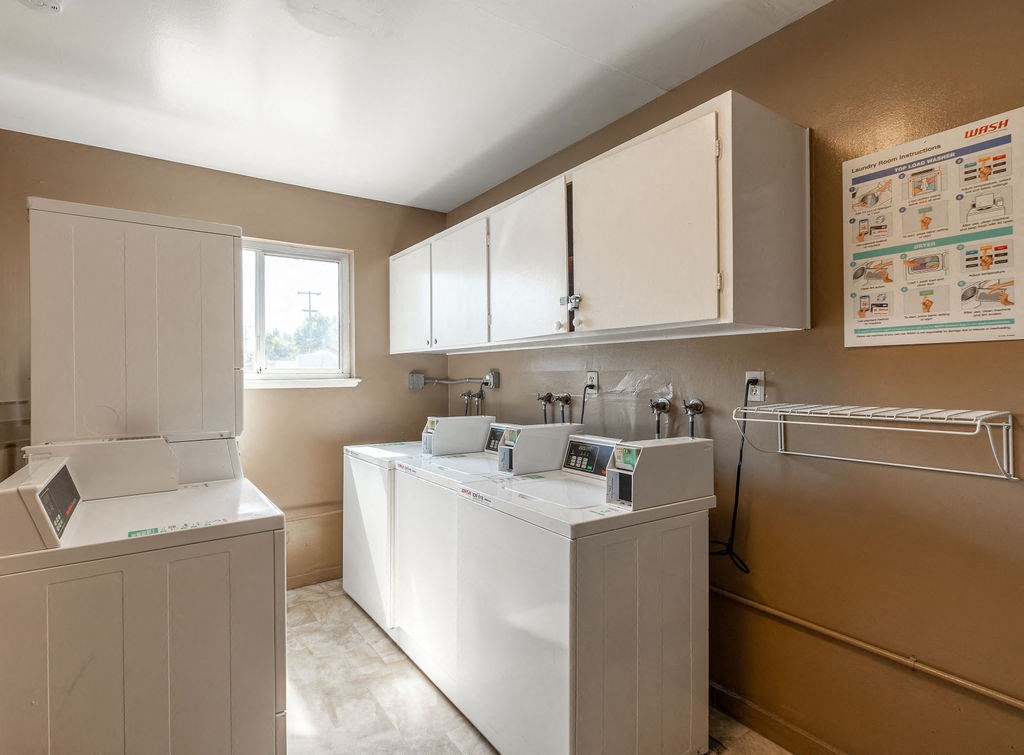 a kitchen with white cabinets and a window