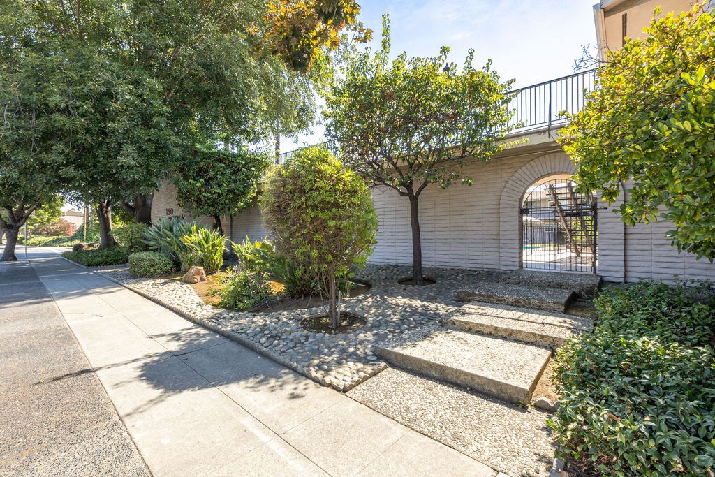 the front yard of a house with stone steps and trees