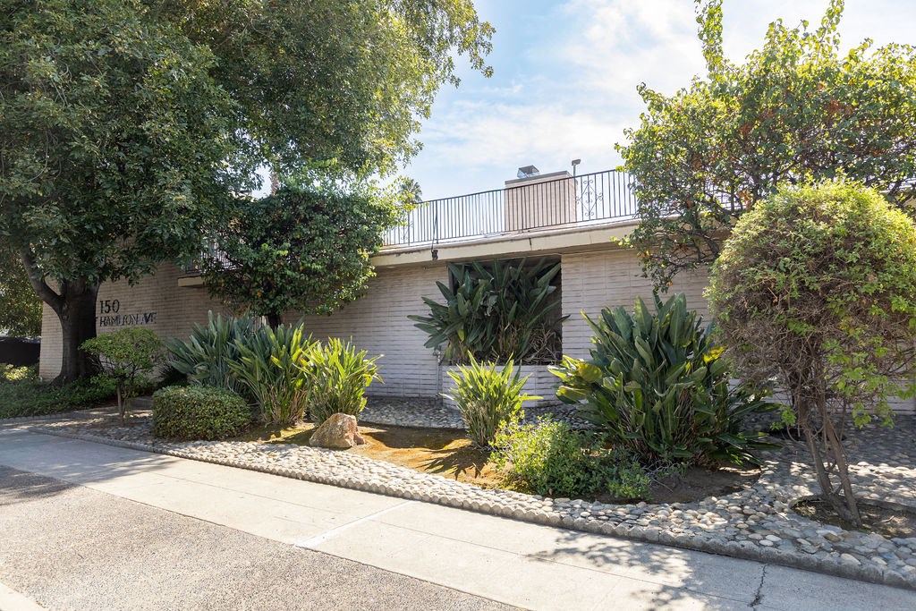 a house with a garden and trees in front of it
